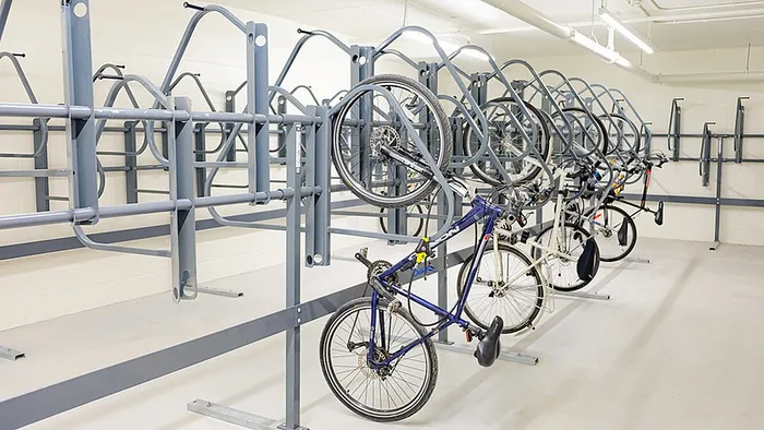 Modern apartment bike storage room with neatly organized bike racks and abundant lighting.
