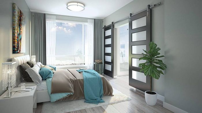 Elegant bedroom featuring modern sliding doors, plush bedding in soothing tones, large window with natural light, and stylish decor.