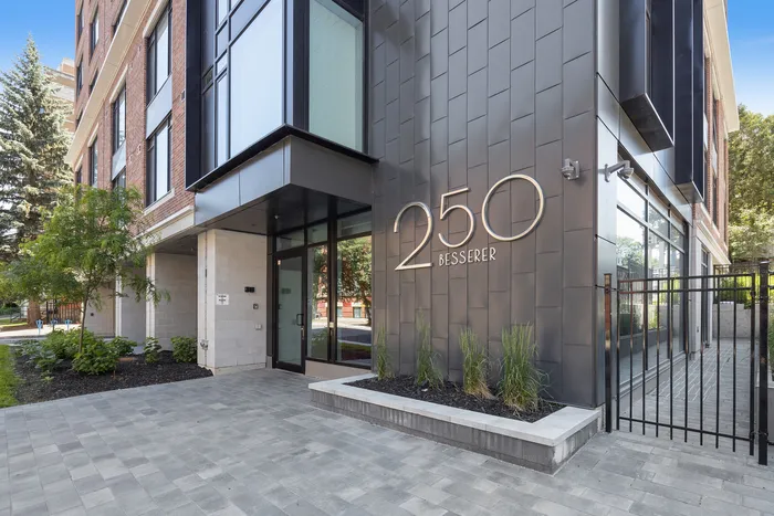 Modern apartment entrance at 250 Besserer with sleek architecture, lush landscaping, and a welcoming walkway.