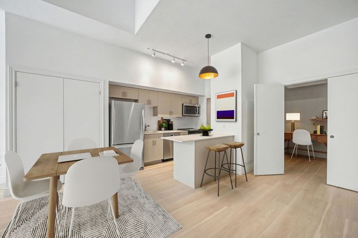 Modern open-plan kitchen with sleek appliances, chic dining area, and stylish home office nook.