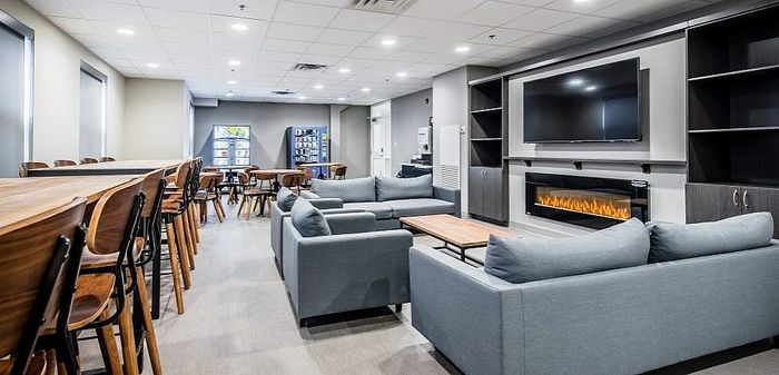 Modern communal lounge area with cozy seating, sleek fireplace, and wall-mounted TV, perfect for relaxation and socializing.