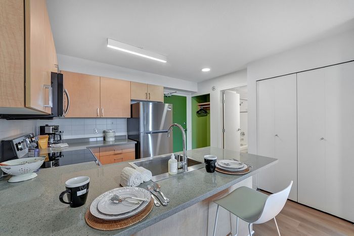 Modern kitchen with sleek countertops, stainless steel appliances, and inviting breakfast bar in a bright apartment.