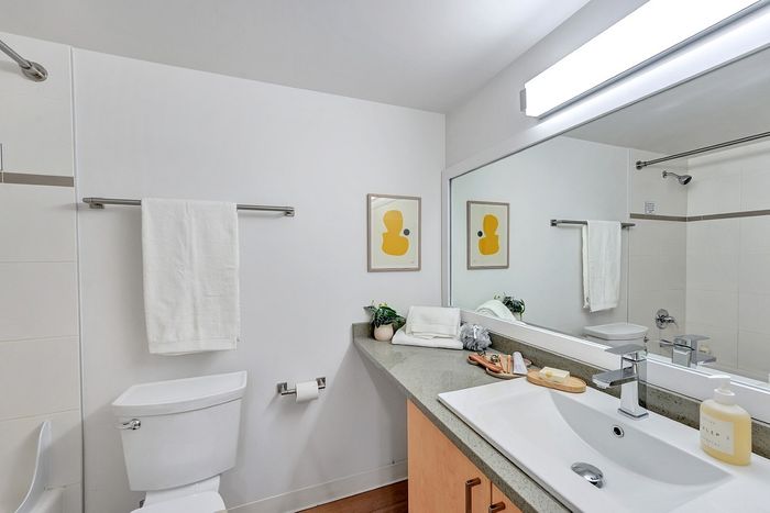 Elegant bathroom featuring a modern sink, large mirror, and contemporary decor with bright artwork.