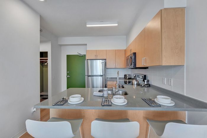 Modern kitchen with sleek stainless steel appliances, spacious countertops, and a stylish breakfast bar set for dining.