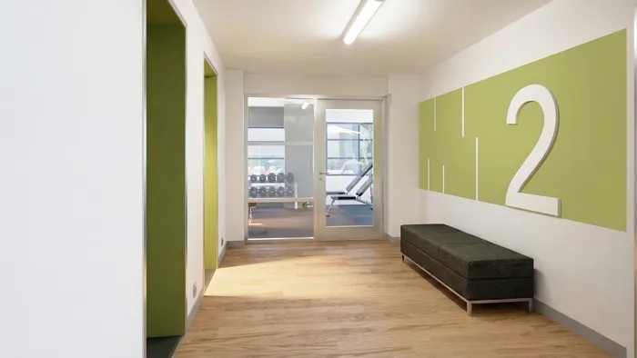 Bright and inviting gym entrance featuring a contemporary design with a green accent wall and modern lighting.
