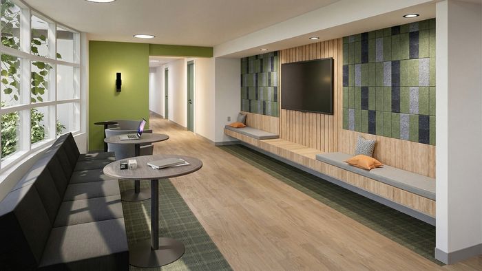 Modern lounge area with stylish seating, large windows, green accent wall, and cozy lighting, perfect for relaxation or work.