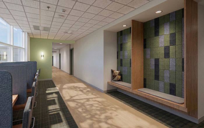 Modern hallway with inviting wall seating, green accent wall, and large windows offering abundant natural light.