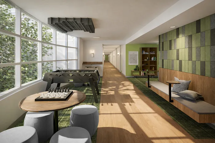 Inviting communal area with stylish seating, a chess table, and foosball, bathed in natural light from large windows.