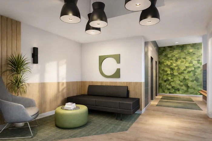 Modern lobby with chic black lighting, stylish seating area, and a vibrant green accent wall, offering a welcoming atmosphere.