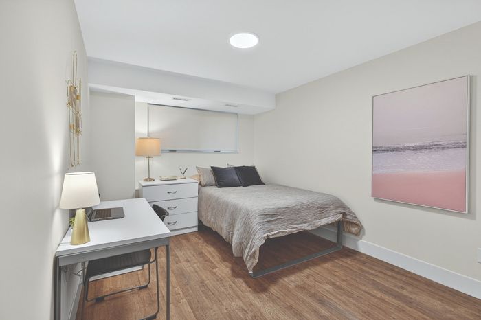 Cozy bedroom featuring stylish decor with modern desk, warm lighting, and serene wall art, offering a tranquil living space.