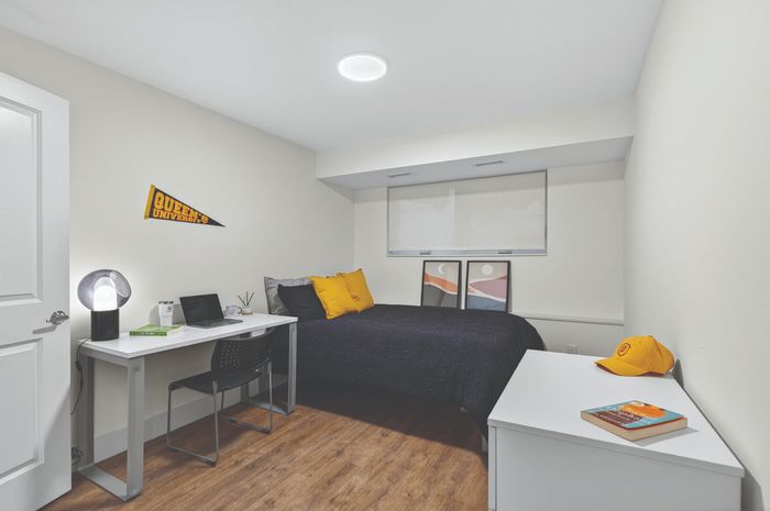 Cozy bedroom with modern decor, featuring a sleek desk setup and vibrant accents.