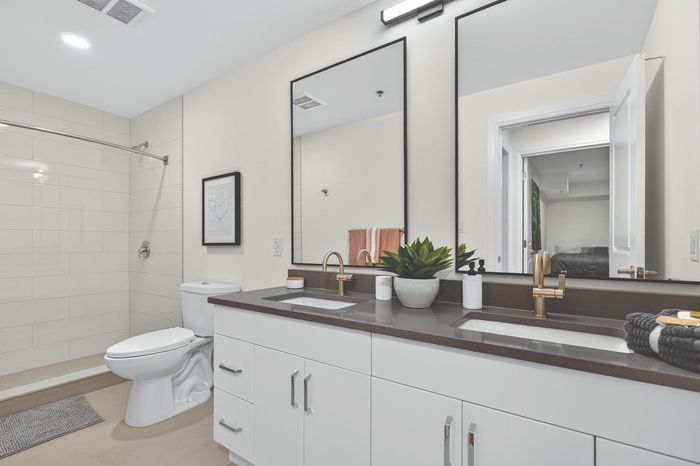 Modern bathroom featuring double sinks, sleek black frames, and elegant fixtures with a refreshing, minimalist design.