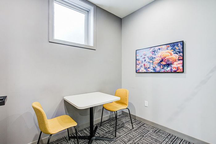 Cozy modern nook with a sleek table and vibrant wall art, perfect for a stylish, intimate setting.