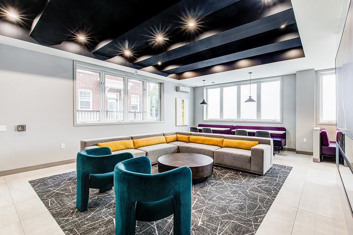 Chic modern lounge featuring plush seating, elegant lighting, and abundant natural light from large windows.