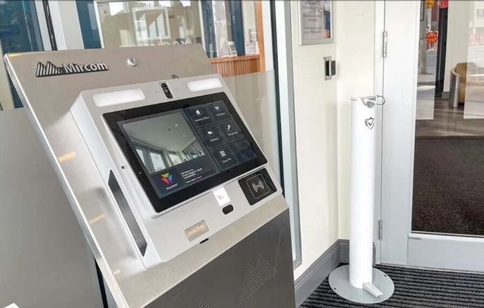 Modern apartment entrance featuring a sleek intercom system with digital display, enhancing security and convenience.