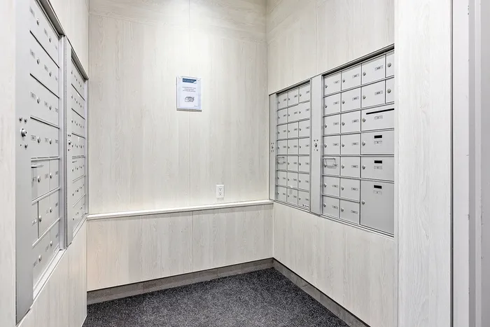 Modern, well-organized mailroom with sleek metal mailboxes and a light wood finish, offering convenience and security for residents.