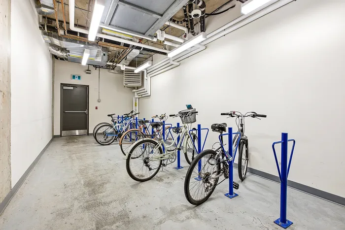 Modern indoor bike storage with secure racks and bright lighting, highlighting a convenient and safe amenity.