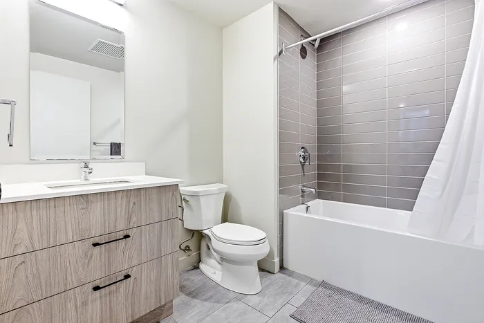 Contemporary bathroom featuring sleek wood cabinetry, modern fixtures, and elegant tiled shower area.