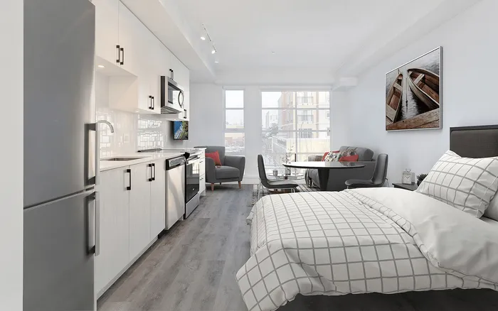 Modern studio apartment with sleek kitchen, cozy seating area, and inviting bed, featuring large windows and stylish decor.