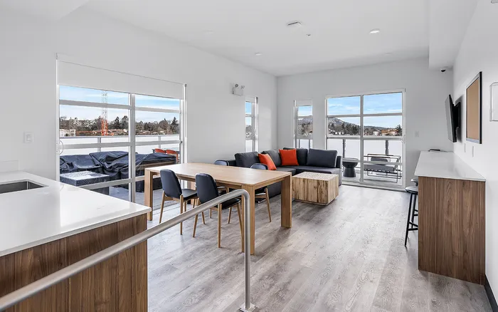 Bright open-plan living area with modern furnishings, floor-to-ceiling windows, and scenic views, ideal for comfortable living and entertaining.