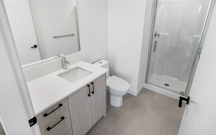 Modern bathroom featuring sleek fixtures, glass shower, and elegant vanity in a stylish apartment.