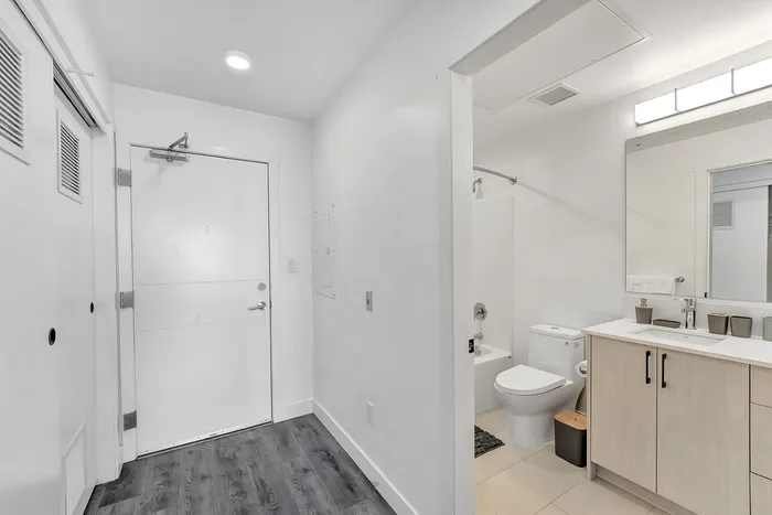 Contemporary apartment entryway with sleek bathroom featuring modern fixtures and elegant cabinetry.