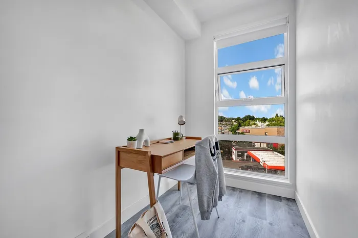 Bright and modern study nook with a sleek wooden desk and a large window offering stunning views, perfect for focused work or study.