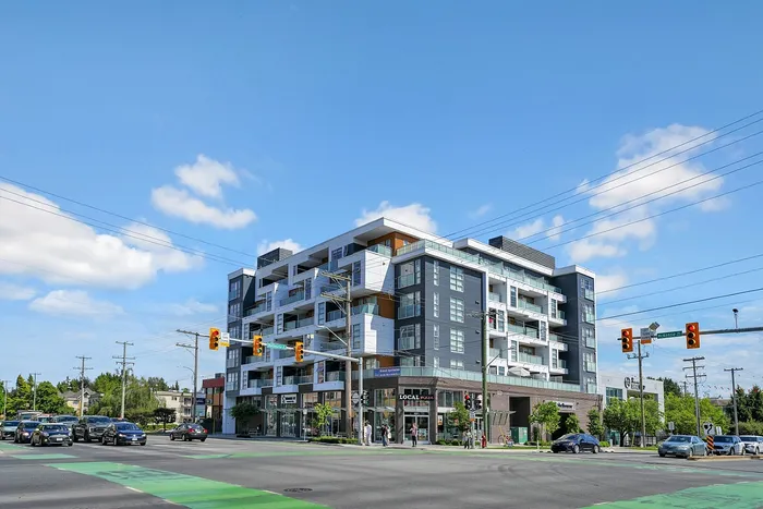 Modern apartment complex on a bustling corner, featuring sleek architecture and vibrant urban surroundings.