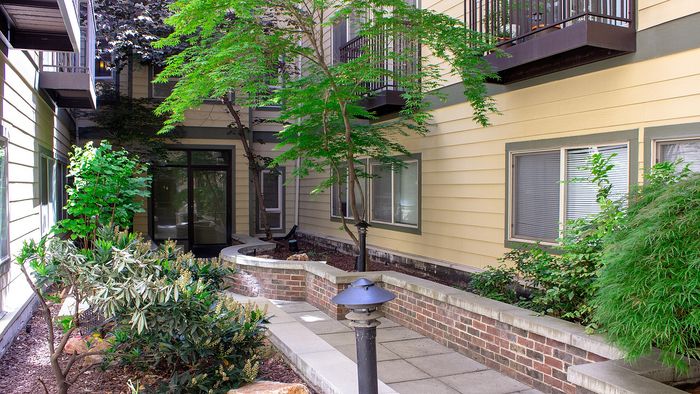 Metro Flats courtyard with landscaped gardens, walkways, and apartment balconies