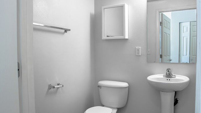 Clean Metro Flats bathroom with pedestal sink, shower area, and modern finishes