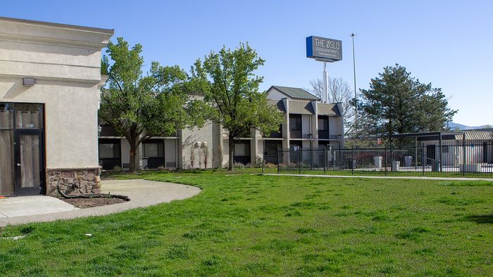 Grassy field next to The Oslo apartments in Murray, Utah with side building view
