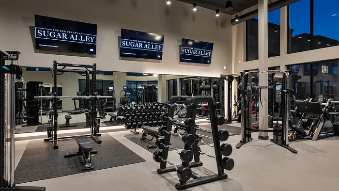 Luxury fitness center at Sugar Alley with modern machines and ambient evening light