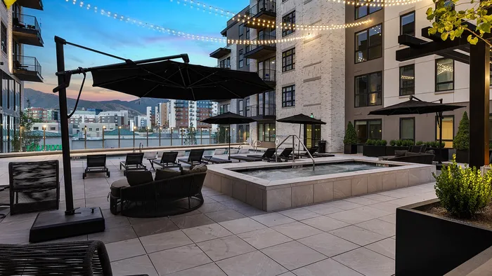 Sugar Alley rooftop pool and hot tub lit by evening light and hanging lights