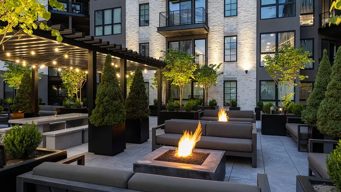 Lounge chairs by fire feature on Sugar Alley pool deck with skyline view