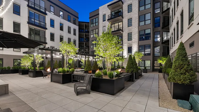 Side angle of rooftop pool and spa at Sugar Alley lit with string lights