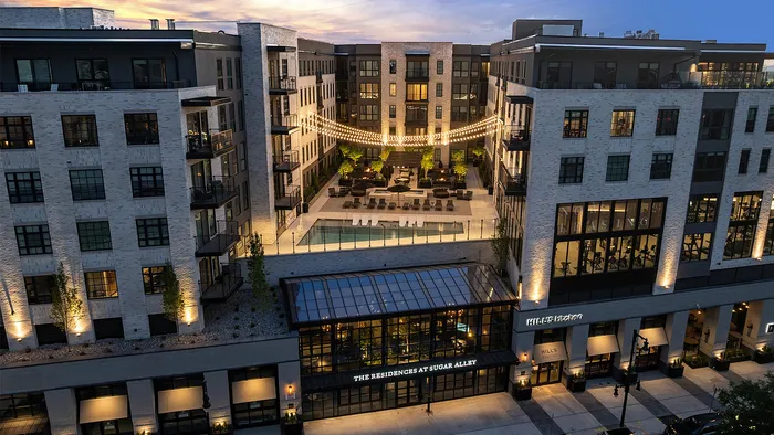 Front-facing view of Sugar Alley Apartments with rooftop pool deck visible