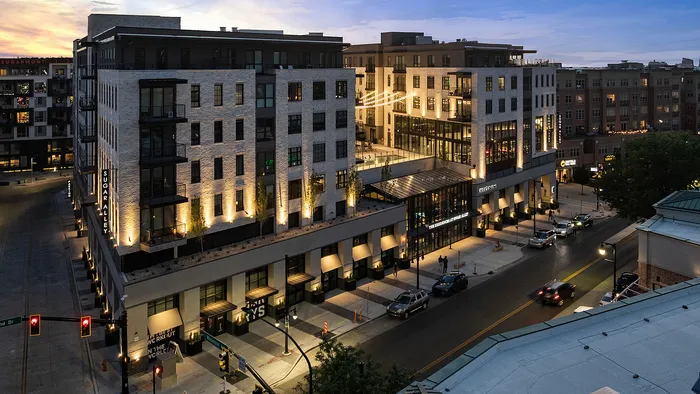 This upper-story shot captures the refined design of Sugar Alley’s exterior, where modern finishes meet expansive glass windows and curated lighting. It’s a residence that feels upscale from the outside in—sophisticated, warm, and inviting.