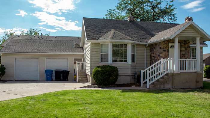 Exterior of remodeled 5-bedroom, 2-bath house for rent at Stone Creek Village in Bountiful with covered parking.