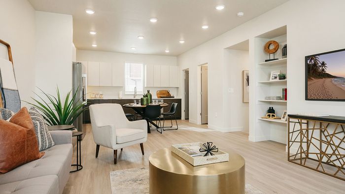 Open-concept great room at RailRunner townhomes with living, dining, and kitchen areas connected.