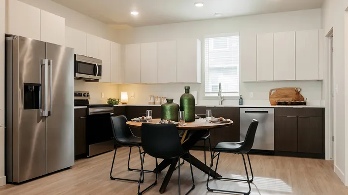 Modern kitchen at RailRunner townhomes with stainless steel appliances, clean cabinetry, and open layout.