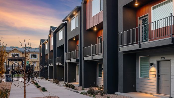 Exterior walkway at RailRunner townhomes showing modern architecture and private entrances.