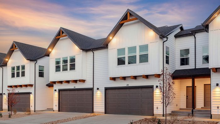 RailRunner townhomes with private garages and modern exterior design at sunset.