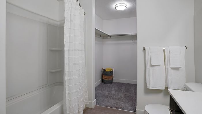 Palisades 2 bedroom apartment bathroom with tub shower and walk-in closet at Parkway Lofts in Orem Uta