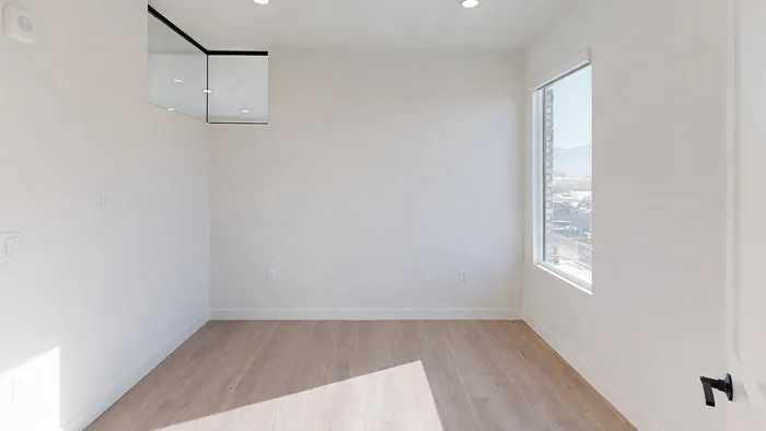 Primary bedroom with large window and natural light in Aster two-bedroom at Silo Park