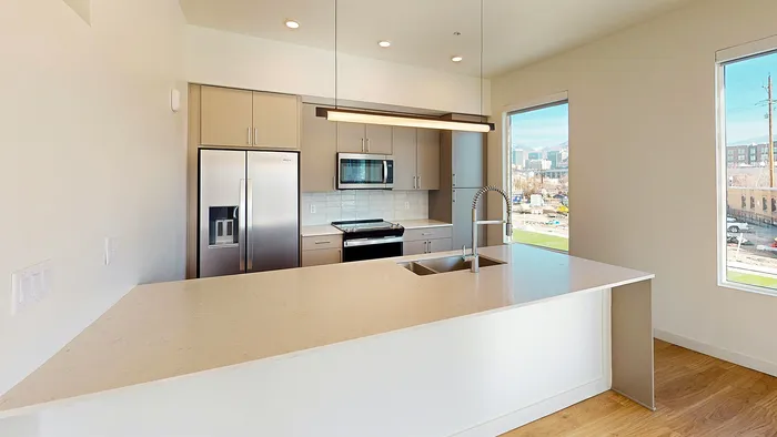 Modern kitchen with large island and stainless steel appliances in Aster two-bedroom at Silo Park