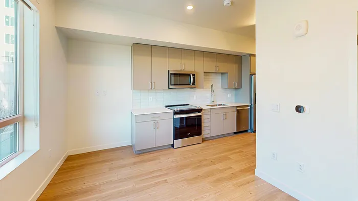 Open-concept studio living area and kitchen in Bluebell floor plan at Silo Park