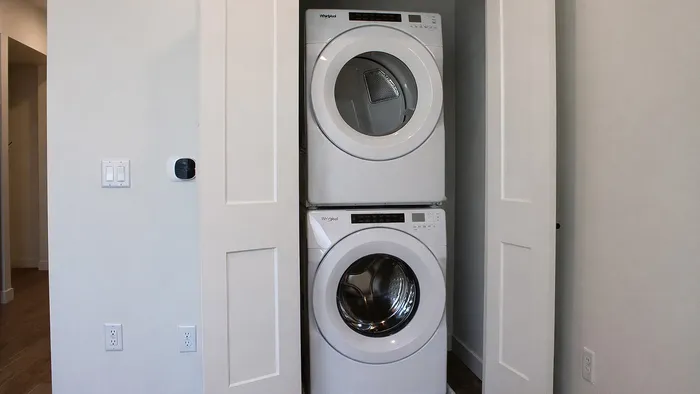 Stacked washer and dryer inside studio apartment at Silo Park