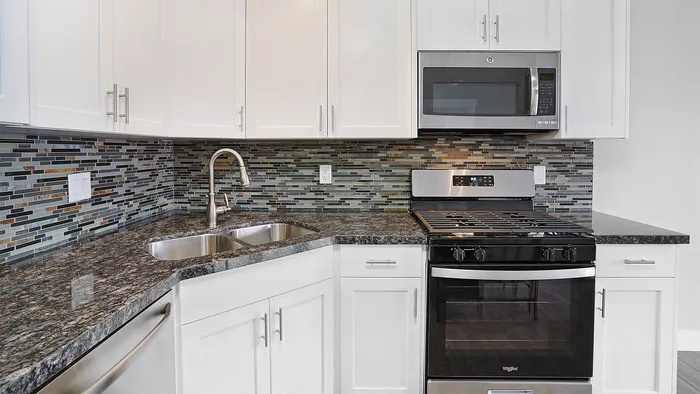Kitchen at Junction View Apartments featuring granite countertops, stainless steel appliances, and modern cabinetry.