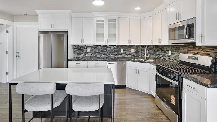Open kitchen at Junction View Apartments with center island, stainless steel appliances, and modern finishes.