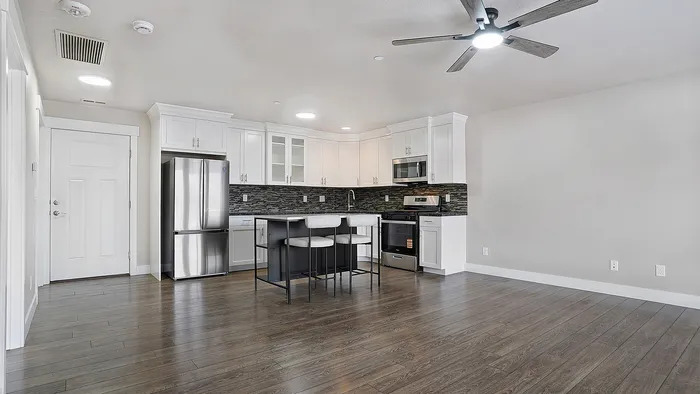 Open concept kitchen and living room at Junction View Apartments with modern finishes and natural light.